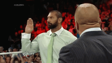 A Man In A Suit Takes A Oath In Front Of A Crowd On A Wrestling Show GIF