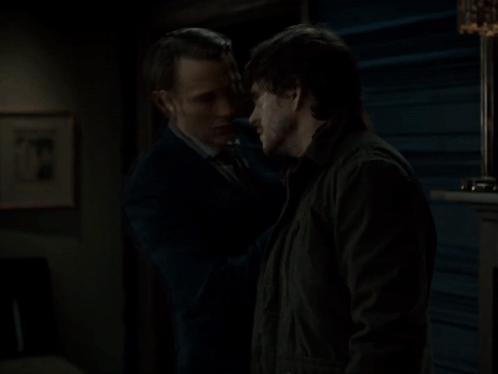 A Man In A Suit Touches Another Man 'S Face GIF