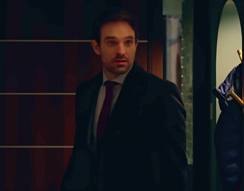 A Man In A Suit With A Red Tie Looks Surprised GIF
