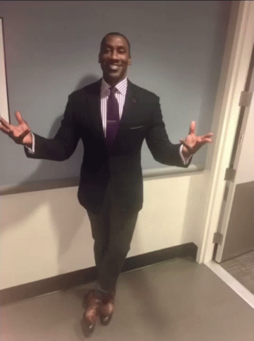 A Man In A Suit With His Arms Outstretched GIF