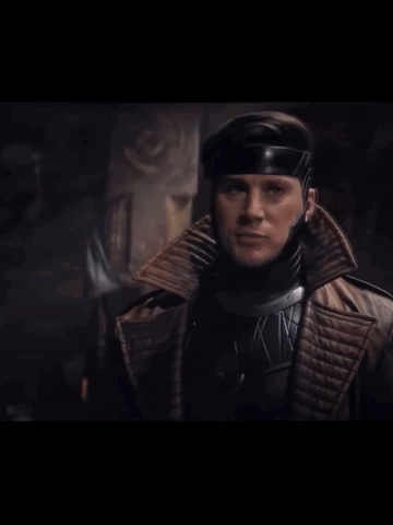 A Man In A Superhero Costume Holds A Purple Card GIF