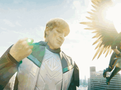 a man in a superhero costume is holding a green object