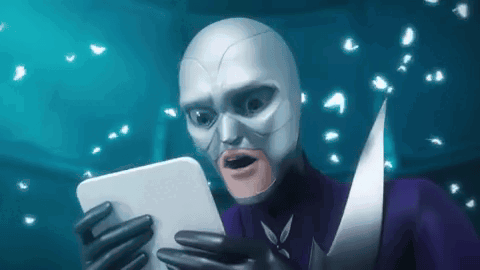 a man in a superhero costume is holding a tablet in his hands .