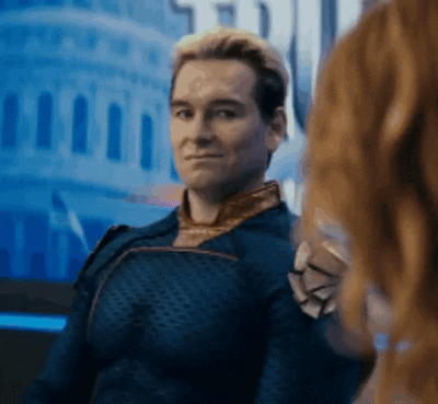 A Man In A Superhero Costume Is Smiling And Looking At Another Man . GIF