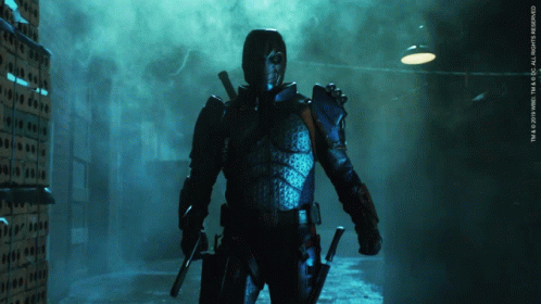 A Man In A Superhero Costume Is Standing In A Dark Room With A Sign That Says Tm & 2010 Wbei GIF