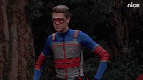 A Man In A Superhero Costume Is Standing In A Forest With The Nick Logo In The Corner GIF