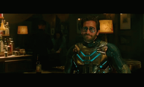 A Man In A Superhero Costume Is Standing In Front Of A Bar GIF