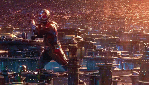 Man In Superhero Costume Standing In Front Of City GIF