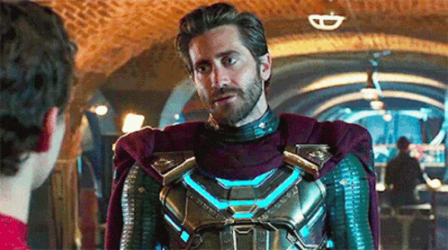 A Man In A Superhero Costume Is Standing Next To Another Man In A Hallway . GIF