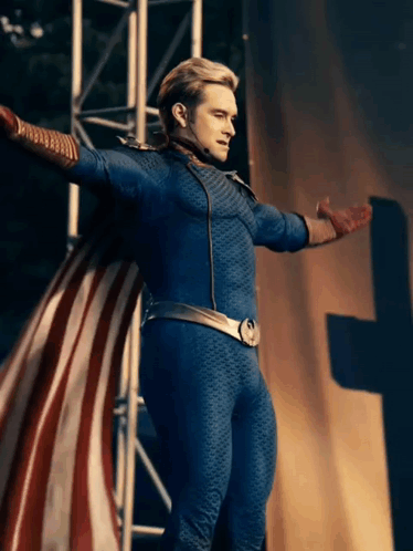 A Man In A Superhero Costume Is Standing With His Arms Outstretched GIF