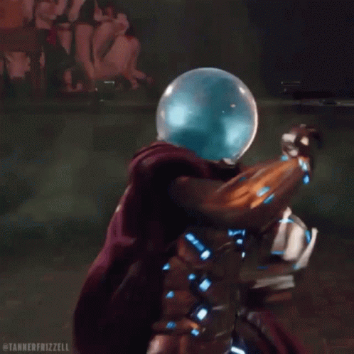 A Man In A Superhero Costume Is Surrounded By Green Smoke And A Glass Ball On His Head . GIF