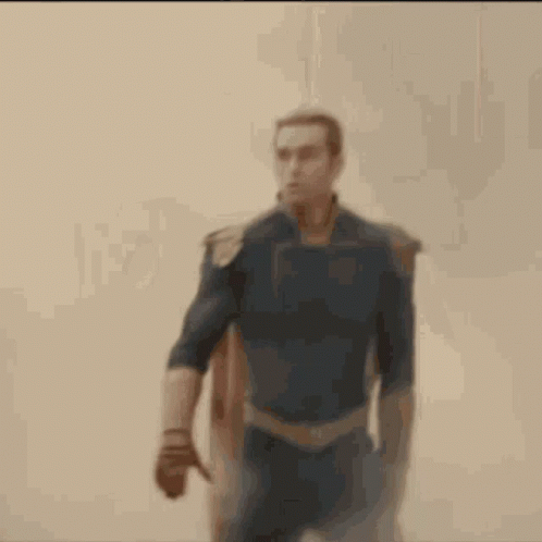 a man in a superhero costume is walking through a cloud of smoke .