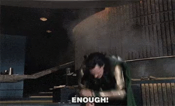 A Man In A Superhero Costume Says " Enough " In Front Of Him GIF