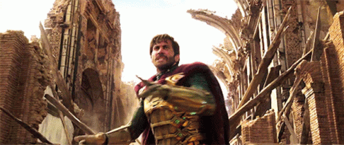 A Man In A Superhero Costume Stands In Front Of A Brick Building GIF
