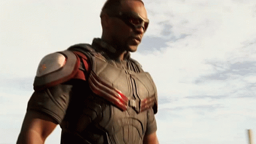 A Man In A Superhero Costume Stands In Front Of A White Sky GIF