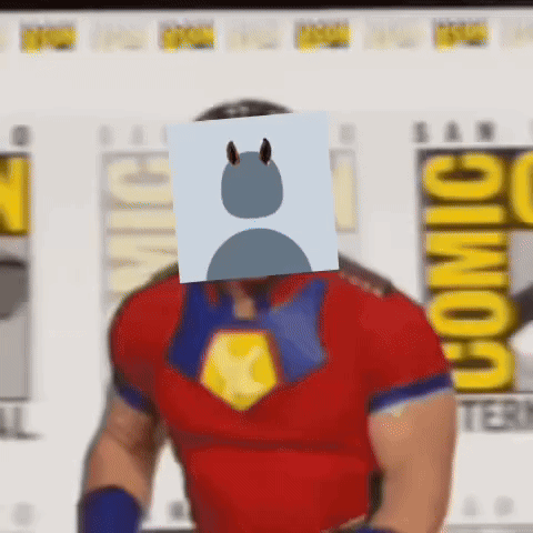 A Man In A Superhero Costume With A Card On His Face . GIF