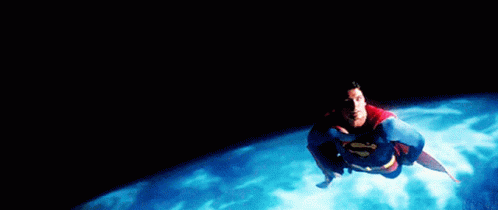 A Man In A Superman Costume Is Flying Over A Body Of Water GIF