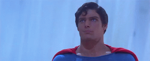 A Man In A Superman Costume Is Giving A Thumbs Up Sign . GIF
