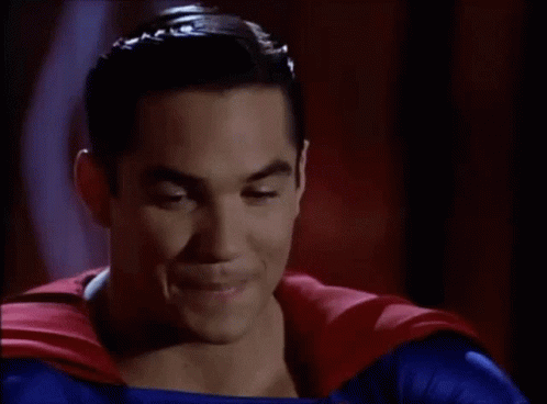 A Man In A Superman Costume Is Smiling For The Camera GIF