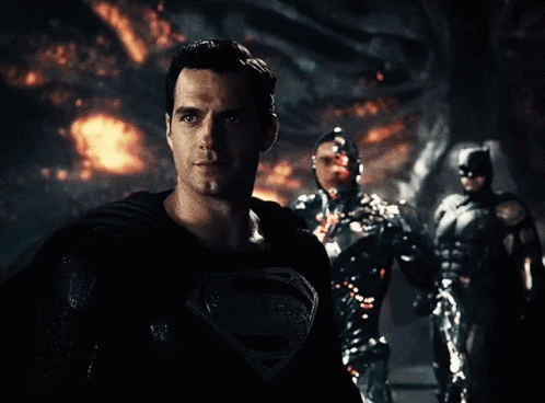 A Man In A Superman Costume Is Standing In Front Of Two Other Superheroes GIF