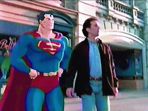 A Man In A Superman Costume Stands Next To A Man In A Brown Jacket GIF