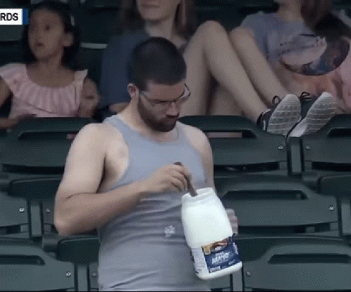A Man In A Tank Top Holds A Container Of Mayonnaise GIF