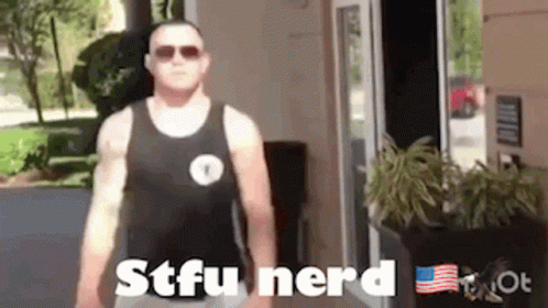 A Man In A Tank Top Is Standing In Front Of A Door . GIF