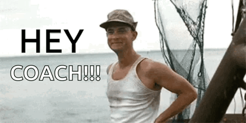 A Man In A Tank Top Stands In Front Of A Sign That Says " Hey Coach " GIF