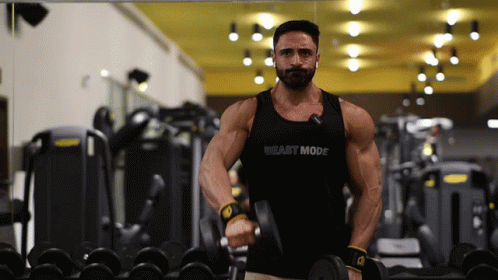 A Man In A Tank Top That Says Beast Mode Is Lifting A Dumbbell GIF