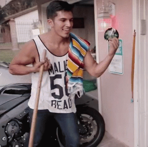 A Man In A Tank Top With The Number 50 On It Is Holding A Broom . GIF
