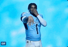 a man in a tennessee titans jersey is dancing in front of a blue background .