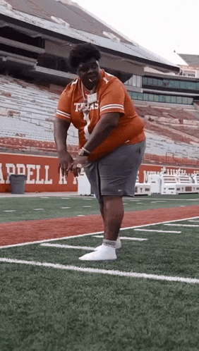 A Man In A Texas Jersey Is Standing On A Football Field GIF