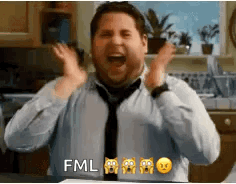 A Man In A Tie Is Making A Funny Face With His Hands In The Air In A Kitchen . GIF