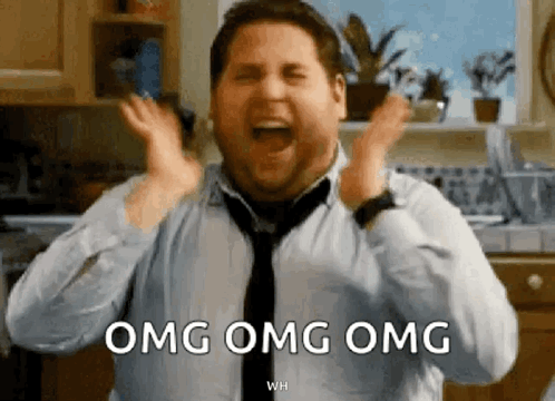 A Man In A Tie Is Screaming In A Kitchen While Holding His Hands Up And Saying Omg Omg Omg . GIF