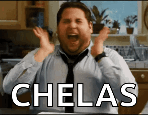 A Man In A Tie Is Screaming In A Kitchen With The Word Chelas Above Him GIF