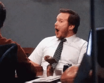 A Man In A Tie Is Sitting At A Table With His Mouth Open . GIF