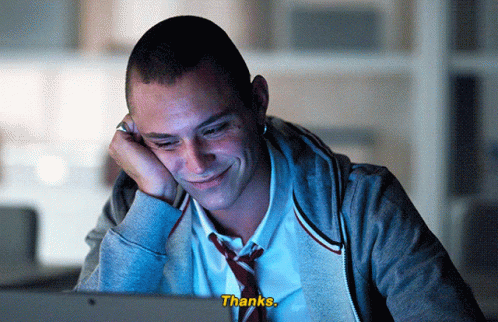 A Man In A Tie Is Smiling While Looking At A Computer Screen And The Words Thanks Are Visible GIF