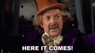 a man in a top hat and bow tie is saying here it comes !