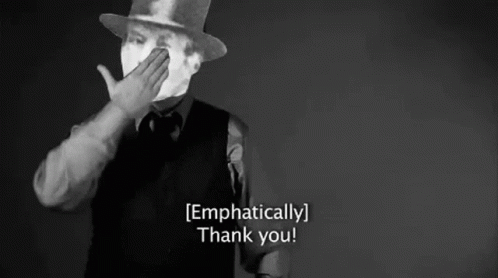 A Man In A Top Hat Is Covering His Mouth With His Hand And Says `` Thank You '' . GIF