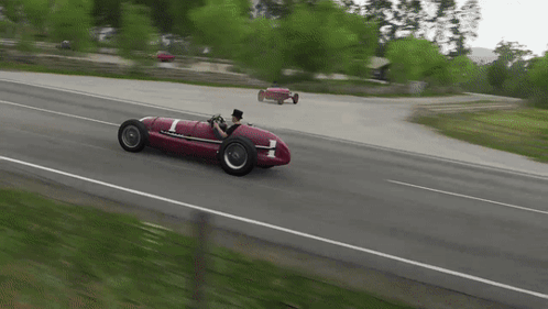 A Man In A Top Hat Is Driving A Red Race Car With The Number 1 On It GIF