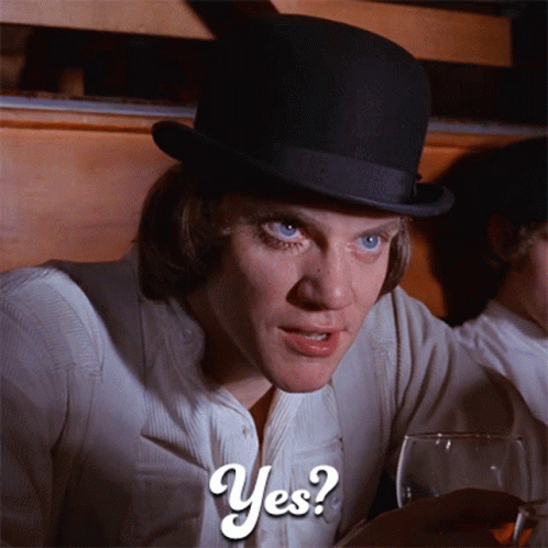 A Man In A Top Hat Is Holding A Glass Of Wine And Says Yes GIF