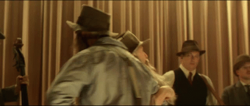 A Man In A Top Hat Stands In Front Of A Curtain GIF