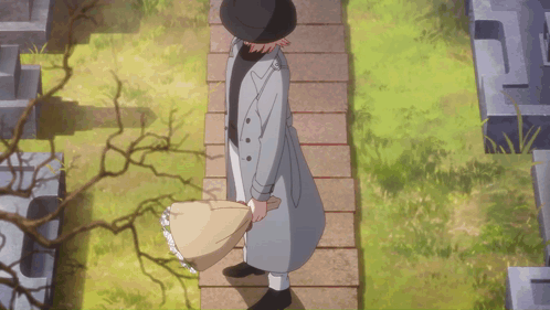 A Man In A Trench Coat And Hat Is Walking Down A Stone Path GIF
