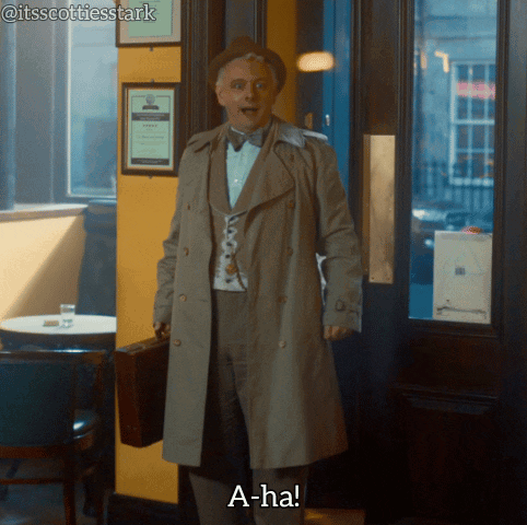 A Man In A Trench Coat Holding A Briefcase Says " A-Ha " GIF