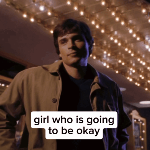 A Man In A Trench Coat Stands In Front Of A Sign That Says Girl Who Is Going To Be Ok GIF