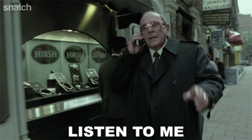 A Man In A Trench Coat Talking On A Cell Phone With The Words Listen To Me Above Him GIF