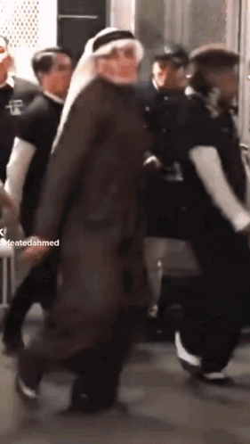 A Man In A Turban Is Walking In A Crowd Of People With A Caption That Says Createdahmed GIF