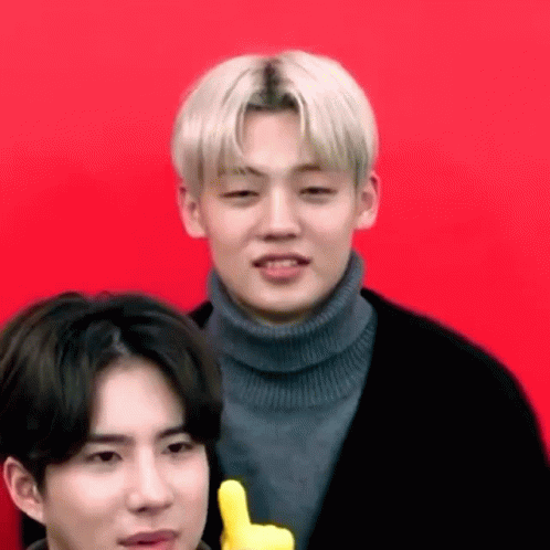 A Man In A Turtleneck Sweater Is Giving A Thumbs Up Sign Next To Another Man In A Black Jacket . GIF