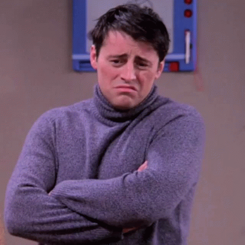 A Man In A Turtleneck Sweater Is Standing With His Arms Crossed . GIF