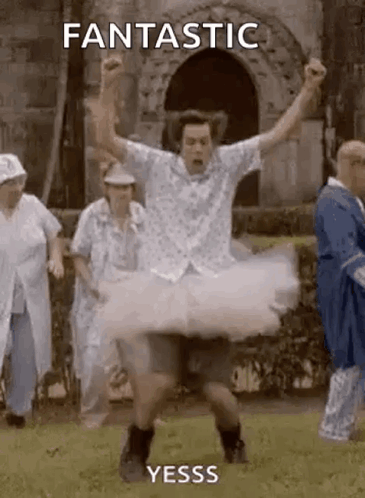 A Man In A Tutu Is Dancing In Front Of A Group Of People In A Park . GIF